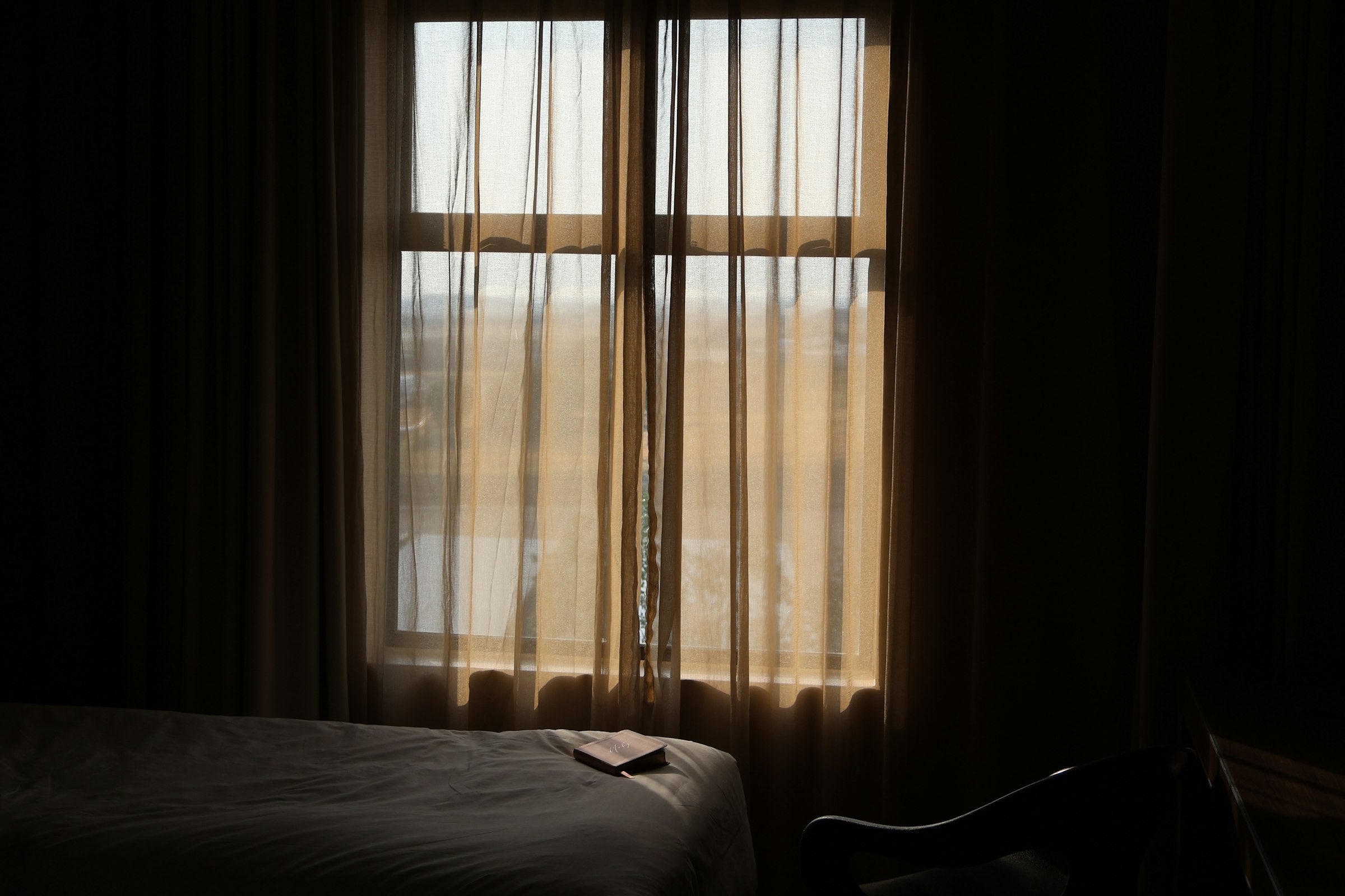 Chambre sombre, lumière du matin à travers les rideaux